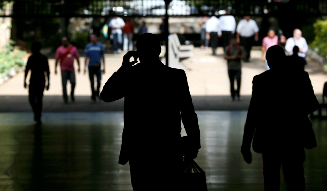 A man uses a mobile phone while walking through an underground mall in a banking district in Brazil.   Bloomberg