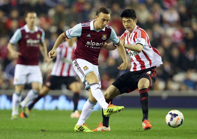 Sunderland’s Ki Sung-yueng (right) and West Ham United’s Mark Noble vie for the ball on Monday.   AFP-Yonhap