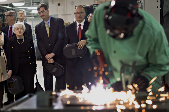 Janet Yellen (left), chair of the U.S. Federal Reserve, and Charles Plosser (second from left), chairman of the Federal Reserve Bank of Chicago, look on as a student uses a cutting torch in the manufacturing lab at Daley College in Chicago, Illinois, Monday.   Bloomberg