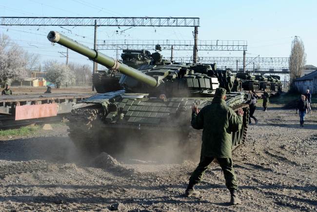 Russian soldiers unload trainload of their modified T-72 tanks after their arrival in Gvardeyskoe railway station near the Crimean capital Simferopol on Monday.   AFP-Yonhap