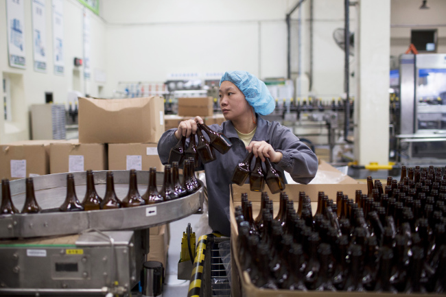 An employee loads bottles onto a conveyor at the Nestle Dongguan Ltd. factory in Dongguan, Guangdong province, China.   Bloomberg