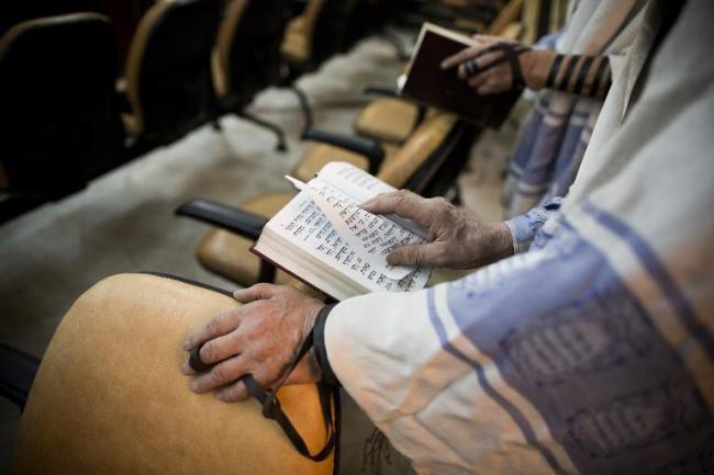 Iranian Jewish men read from the Torah during morning prayers at Youssef Abad synagogue in Tehran on Sept. 30.   AFP