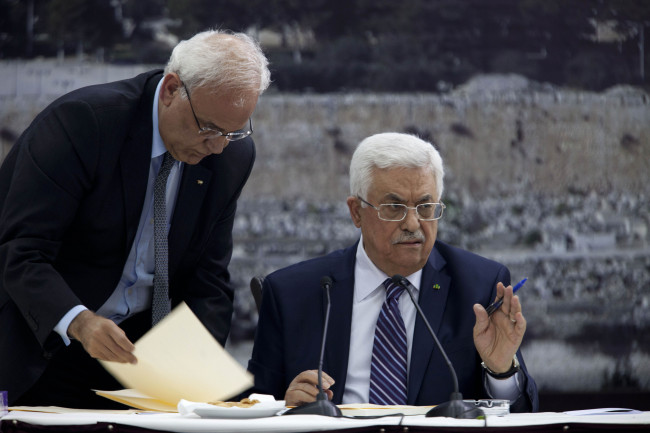 Palestinian President Mahmoud Abbas (right), joined by Palestinian chief peace negotiator Saeb Erekat, signs an application to the U.N. agencies in Ramallah, West Bank, Tuesday.   AP-Yonhap