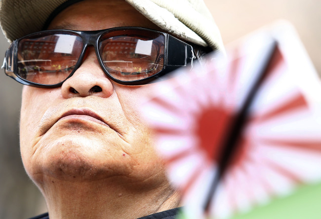 A South Korean man attends a demonstration in Seoul on Wednesday against Japan’s decision to ease its arms exports ban.   Yonhap