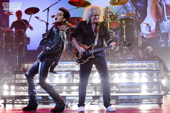 Adam Lambert (left) and members of iconic rock band Queen perform together on stage.   Super Sonic