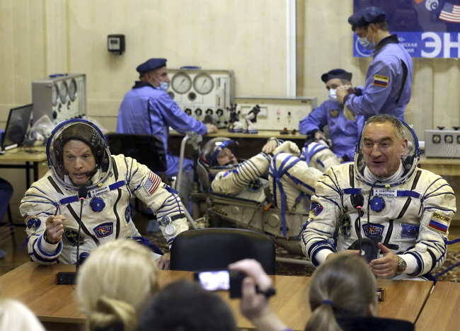 This March 25 file photo shows U.S. astronaut Steven Swanson (left) and Russian cosmonaut Alexander Skvortsov during pre-launch preparations in Kazakhstan.   AFP-Yonhap