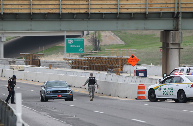 A military police officer stops a car at Fort Hood, Texas, after a shooting on the army base Wednesday.   AP-Yonhap
