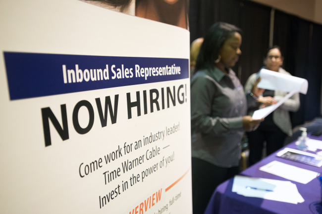 A “Now Hiring” sign stands at an exhibitors’ table at the Columbus Career Fair in Columbus, Ohio.   Bloomberg