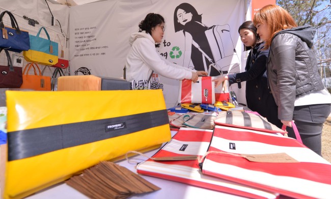 Visitors look at products at the Herald Design Market at The-K Seoul Hotel in Seoul, Sunday, as part of the three-day K-Style Design Festival. The three-day event, which ended on the day, featured a lecture by a young entrepreneur from the U.K., an organic food party and a market selling creative, eco-friendly products.   Lee Sang-sub/The Korea Herald