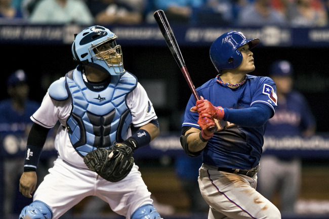 Texas Rangers left fielder Choo Shin-soo hits a sacrifice fly in the fourth inning on Saturday. The Korean went 2 for 4 with an RBI.   AP-Yonhap