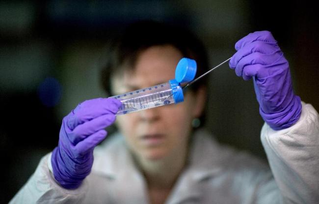 This photo shows microbiologist Dr. Molly Freeman pulling Listeria bacteria from a tube to be tested for its DNA fingerprinting in a foodborne disease outbreak lab at the federal Centers for Disease Control and Prevention in Atlanta.   AP
