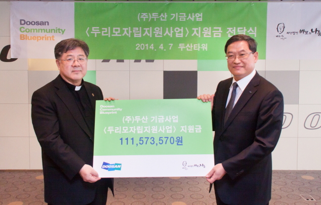 최광주 ㈜두산 사장(오른쪽)이 7일, 서울 중구 두산타워에서 조규만 바보의 나눔 이사장에게 ㈜두산 임직원들이 자발적으로 조성한 두리모자립지원사업 지원금 을 전달하고 있다. [사진=두산]