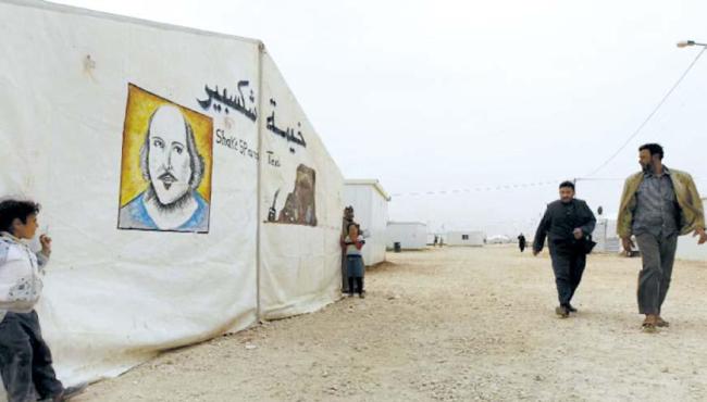 Syrian refugees walk past the “Shakespeare tent,” where children are rehearsing “King Lear,” one of Shakespeare’s great tragedies, at the sprawling Zaatari refugee camp in Jordanian desert near the border with Syria. (AFP)