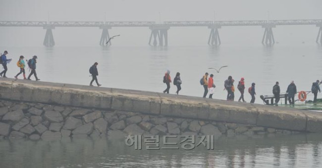 서울 등 중부내륙과 서해안에 짙은 안개가 낀 9일 오전 영종도 삼목선착장에서 한 관광객이 안개속을 걸으며 장봉도로 트레킹을 가고 있다.