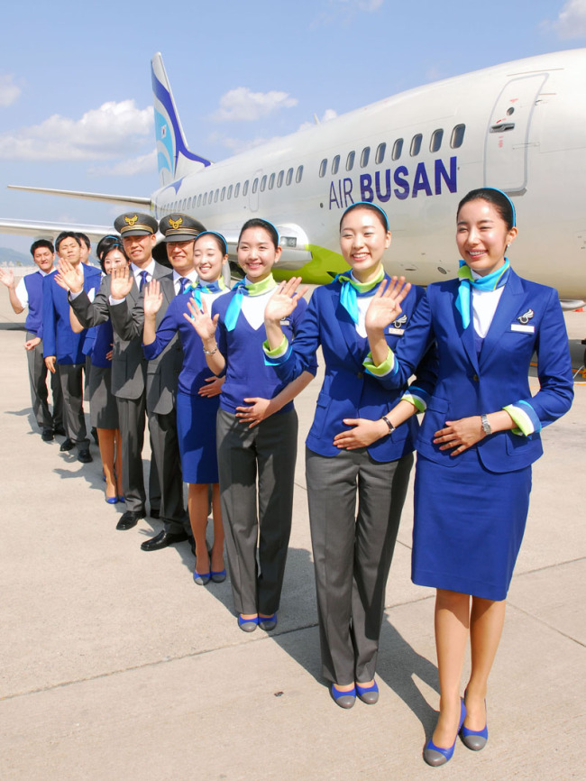Air Busan crew pose in front of one of the airline’s planes.   Air Busan