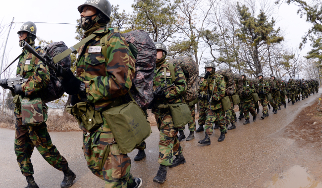 Army recruits in full gear march as part of their five-week basic training at a boot camp in Nonsan, South Chungcheong Province.   Ahn Hoon/The Korea Herald