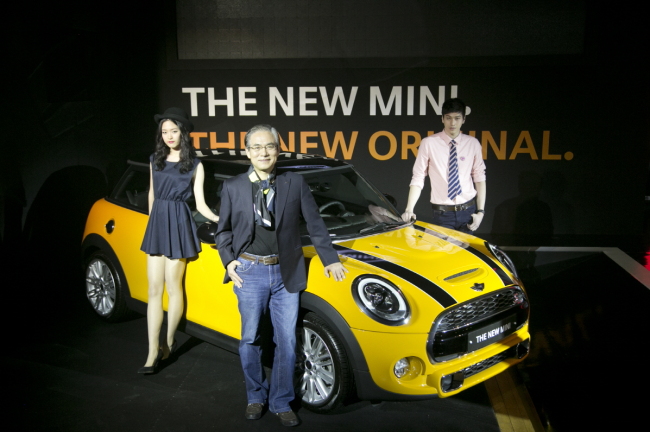 BMW Korea chief executive Kim Hyo-joon (center) and models pose next to BMW’s new third-generation Mini Cooper at a launch in Paju, Gyeonggi Province, Thursday. The local price is set at 29.9 million won ($28,700) for the new Mini Cooper, 37.2 million won for the premium option and 42.4 million won for the Cooper S.   BMW Korea
