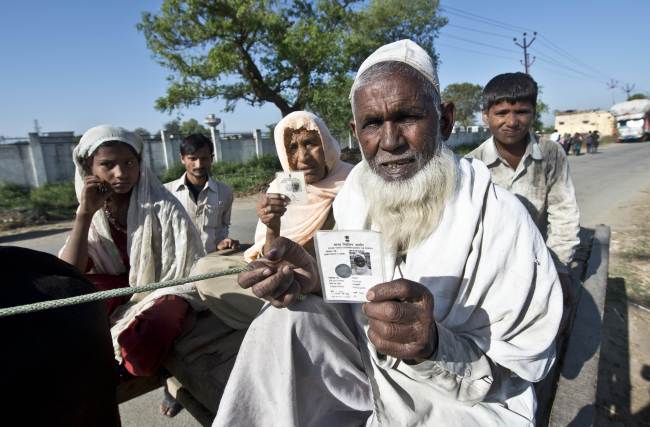 An Indian resident Ramjan (right) and his wife pose with their voting cards after casting their votes at a polling center in the village of Jaula in Muzaffarnagar district, India, Thursday.   AFP-Yonhap