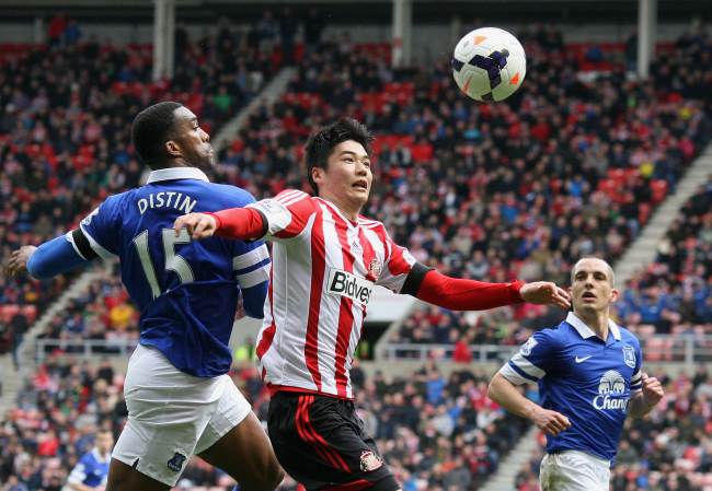 Sunderland’s Ki Sung-yueng (center) and Everton’s Sylvain Distin vie for the ball on Saturday.   AFP-Yonhap