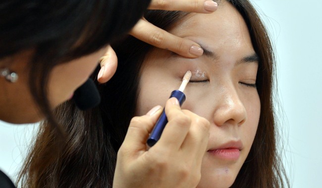 A makeup artist offers tips on applying eye makeup.   Lee Sang-sub/The Korea Herald