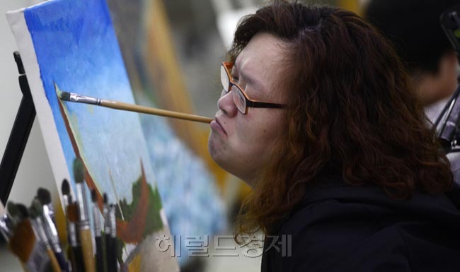 송파구가 제34회 장애인의 날(4월20일)을 맞아 16일 오전 송파구민회관에서 장애인 그림 동호회 <화사랑> 그림 시연회 및 전시회를 개최한 가운데 장애인 화가인 이현정(40, 여)가 캔버스에 유화를 그리고 있다.