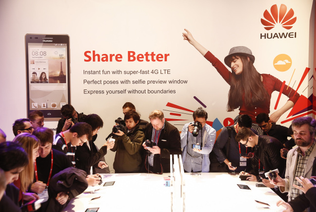 Attendees inspect and photograph the new MediaPad M1 devices during a Huawei Technologies news conference at the World Mobile Congress in Barcelona, Spain in February this year.                    (Bloomberg)