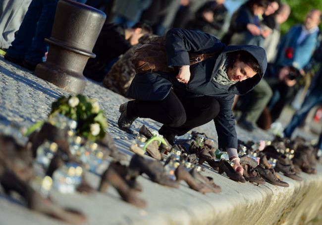A young woman pays respects at the “Shoes Statue of a Memorial Place of the Holocaust Victims” on the bank of the Danube River in downtown of Budapest on April 16 during the Holocaust memorial day.  AFP-Yonhap