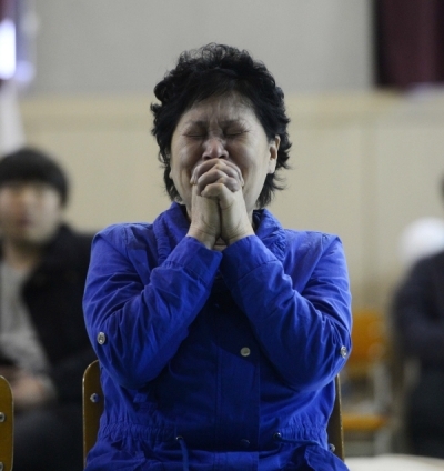 A mother of a missing student prays for the safe return of her child at Danwon High School in Ansan, Gyeonggi Province, Thursday. (Park Hae-mook/The Korea Herald)
