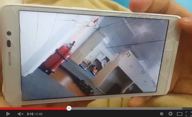 A cracked smartphone screen playing footage shows the sinking process of the Sewol. (photo: Youtube)