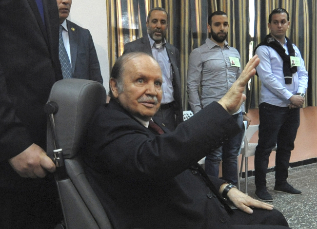 Algerian President Abdelaziz Bouteflika, sitting in a wheelchair, waves as he arrives to vote in the presidential elections in Algiers on Thursday.   AP-Yonhap