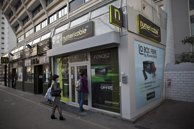 Customers enter a Numericable SA cable-television and Internet store in Paris.   Bloomberg