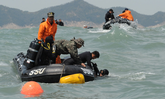 <YONHAP PHOTO-0817> <여객선침몰> 사고현장의 해난구조대와 특수전전단 (서울=연합뉴스) 세월호 사고현장에서 해군 해난구조대(SSU)와 특수전전단(UDT/SEAL) 소속의 잠수사들이 고무보트를 타고 높은 파도와 강한 조류와 싸우며 실종자 탐색구조작전을 펼치고 있다. 2014.4.20 << 해군 >> dohh@yna.co.kr/2014-04-20 15:54:23/ <저작권자 ⓒ 1980-2014 ㈜연합뉴스. 무단 전재 재배포 금지.>
Members of the Navy’s Ship Salvage Unit engage in search operations for the ferry Sewol’s passengers on Sunday off the coast of Jindo Island, South Jeolla Province.   Navy