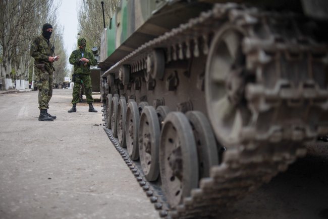 Pro-Russian protesters stand near a seized armored vehicle in front of an occupied police station in Slavyansk, Ukraine, Saturday.   EPA-Yonhap