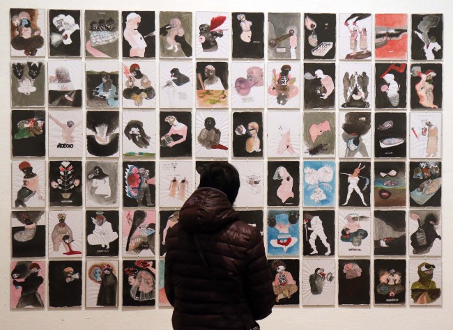 A visitor looks at pictures in the exhibition “I Am A Drop In The Ocean” at the Kuenstlerhaus gallery in Vienna, Austria, April 10. (AP-Yonhap)