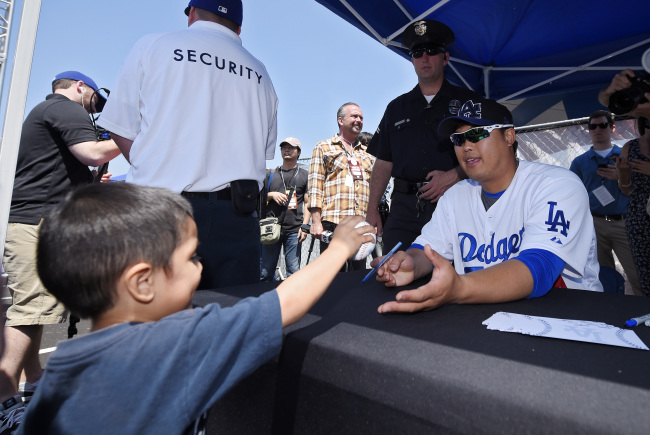 Los Angeles Dodgers pitcher Ryu Hyun-jin signs autographs prior to a game against the Arizona Diamondbacks on Sunday.   AP-Yonhap