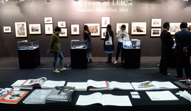 Visitors look at photographs and photographic equipment on display at the “100 years of Leica” exhibition at the Coex Convention Center on Thursday.   Ahn Hoon/The Korea Herald