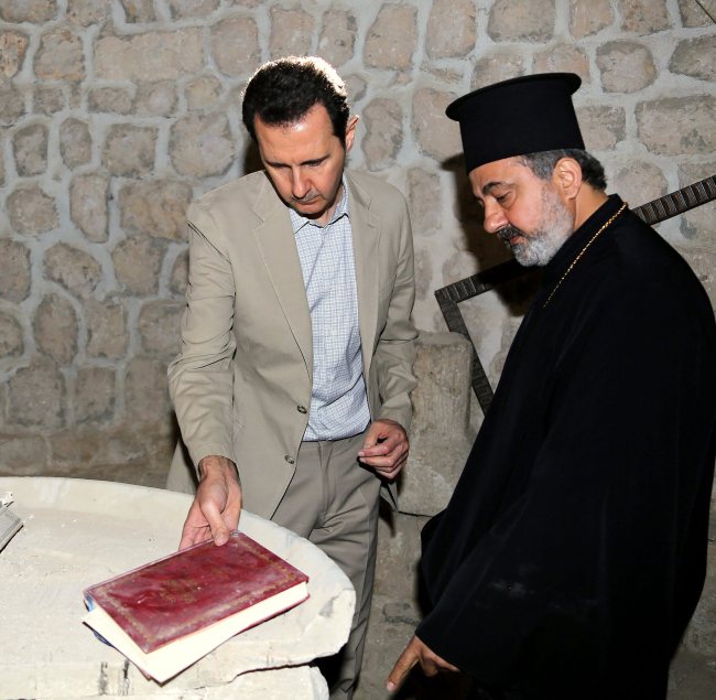 A handout picture made available by the official government Syrian Arab News Agency shows Syrian president Bashar Assad (right) during his visit to the predominantly Christian city of Maaloula, Syria, Monday.   EPA-Yonhap
