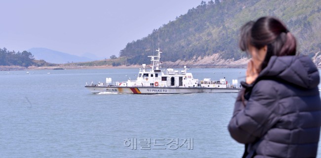 세월호 침몰사건이 일어난지 엿새째인 21일 오후 전남 진도군 팽목항에서 실종자가족이 세월호 침몰지역으로 떠나는 구조선을 보며 실종된 가족이 살아 돌아오기를 기도하고 있다.