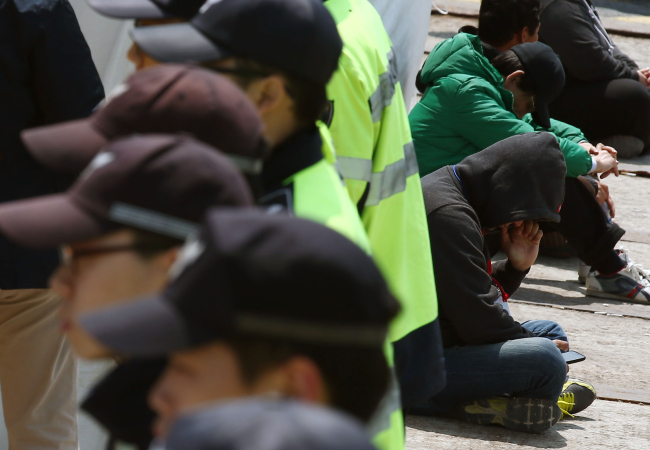 Families of the Sewol’s missing passengers wait for news behind the police line at Paengmok Port on Jindo Island, South Jeolla Province, Monday.   Yonhap