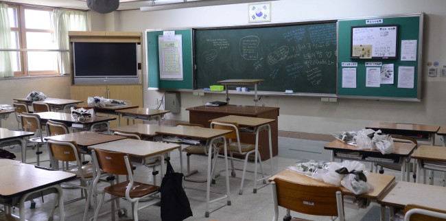 Flowers are laid on the desks in Danwon High School in Ansan, Gyeonggi Province, Tuesday in condolence to the students who lost their lives during last week’s ferry sinking.   Park Hae-mook/The Korea Herald