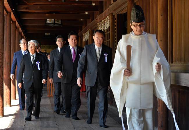 Japanese lawmakers follow a Shinto priest (right) during a visit to the controversial Yasukuni Shrine to honor the war dead at shrine’s spring festival in Tokyo on Tuesday.   AP-Yonhap