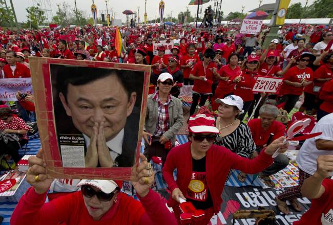 A Thai pro-government “Red Shirts” protester holds a portrait of fugitive former Prime Minister Thaksin Shinawatra during a rally in the Phutthamonthon suburb of Bangkok on April 5.   AFP-Yonhap