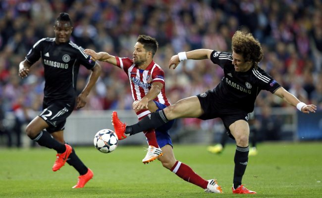 Atletico Madrid’s Diego Ribas (center) vies for the ball with Chelsea’s John Obi Mikel (left) and David Luiz.   EPA-Yonhap