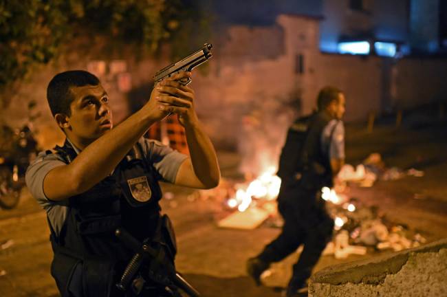 A Brazilian Police Special Forces member takes position during a protest in a favela near Copacabana in Rio de Janeiro, Brazil, Tuesday.   AFP-Yonhap