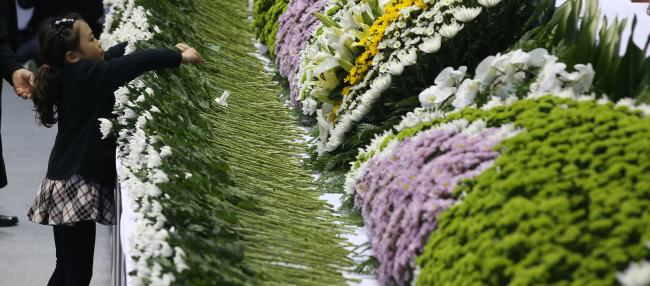 23일 오후 경기도 안산 올림픽기념관에 침몰 세월호의 단원고 희생자를 위한 임시 합동분향소가 마련돼 한 어린이가 헌화하고 있다. (연합)