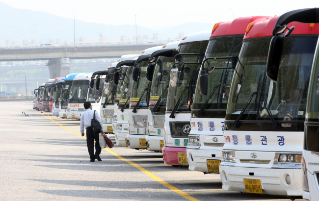 Tourist buses sit idle in a parking lot in southern Seoul on Wednesday.   Yonhap