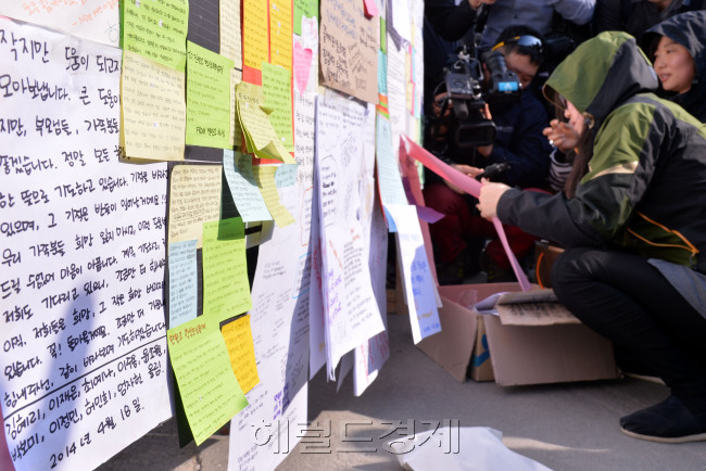 23일 오후 여객선 세월호 침몰사고와 관련하여 전남 진도군 팽목항에 전국에서 보낸 무사귀환 희망메세지를 진도군 관계자가 붙이고 있다.<br />진도=이상섭 기자. babtong@heraldcorp.com