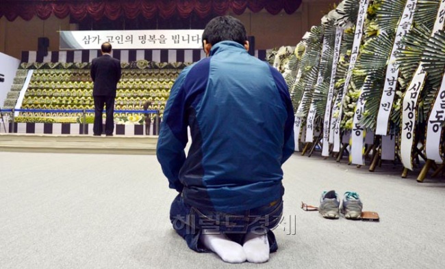 24일 오전 안산시 단원구 고잔동 안산올림픽기념관 실내체육관에 마련된 ‘세월호 참사 희생자 임시분향소’에서 한 추모객이 무릎을 꿇고 고인들의 넋을 기리고 있다.