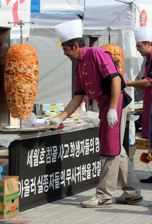 Turkish men prepare kebabs at an outdoor kitchen set up in front of Jindo Gymnasium on Jindo Island, South Jeolla Province, Thursday.   Yonhap