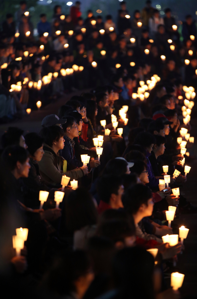 Citizens participate in a candlelight vigil at a park in Ansan, Gyeonggi Province, Thursday night.   Yonhap